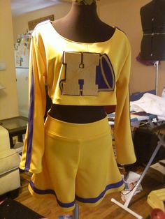 a female mannequin dressed in yellow and blue clothing with an ironing board on it's chest