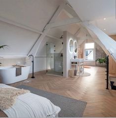 an attic bathroom with wooden floors and white walls, along with a free standing tub