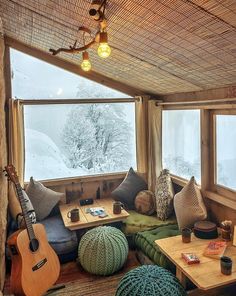 a living room filled with lots of furniture next to a large window covered in snow