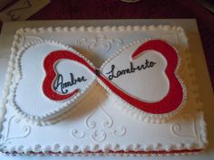 a heart shaped cake with the word love written on it and two hearts in the middle