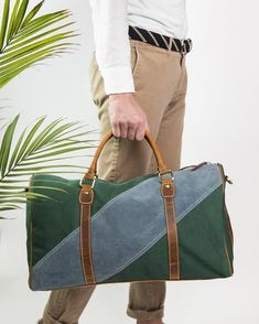 The FH Wadsworth Green Canvas & Blue Suede Duffel Bag is both stylish and functional. Made from a heavy duty green canvas and coupled with a diagonal light blue strip of suede. Brown full grain leather accents and side suede strips provide the perfect pop of color. This modern weekender bag brings luxury, durability, and timelessness to any destination. Conveniently meets all airline carry-on size requirements. Interior zipper pocket Detachable leather strap for shoulder or cross-body wear 2 Green Coated Canvas Bags With Leather Trim, Green Canvas Weekender Bag With Large Capacity, Large Capacity Green Canvas Weekender Bag, Green Duffle Bag With Leather Handles For Daily Use, Green Duffle Bag With Leather Handles For Everyday, Green Rectangular Travel Bag With Leather Handles, Everyday Green Duffle Bag With Leather Handles, Green Leather Travel Bag With Luggage Sleeve, Casual Green Bags With Leather Trim