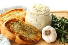 garlic bread with cream cheese and herbs on a cutting board