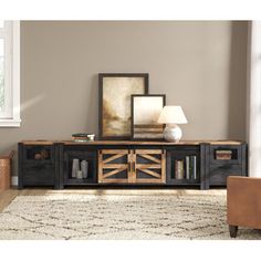 a living room with a couch, chair and entertainment center in the middle of it