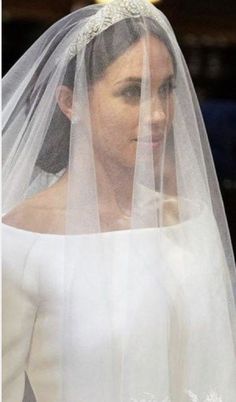 the bride is wearing a white veil and tiara