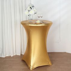 a gold table with flowers and wine glasses on it