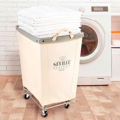 a stack of towels sitting on top of a laundry basket next to a washing machine