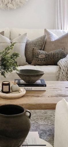 a living room filled with lots of furniture and pillows on top of a wooden table