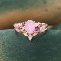 an opal and diamond ring with pink stones