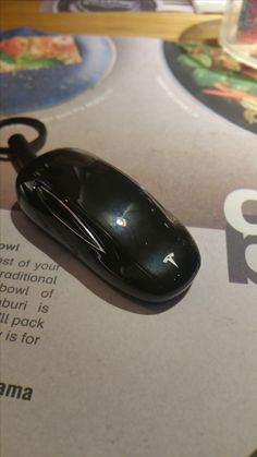 a black computer mouse sitting on top of a brochure with the amazon logo