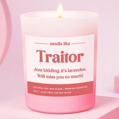 a pink candle that is on top of a white box with the words traitor printed on it