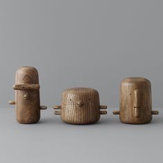 three wooden objects sitting on top of each other in front of a gray background with lines