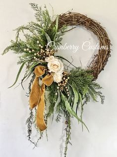 a close up of a wreath with flowers and greenery on the front of it