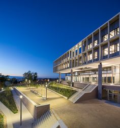 the building is lit up at night and has stairs leading up to it's entrance