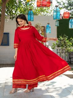 Royal Solid Red Round Neck Anarkali Waist Gathered Kurta Paired with Red Plazzo and Chanderi Dupatta Golden Work on it. Neck: Round Neck Sleeve Length: 3/4th Kurta Length: Ankle Length Work Type: Gota Patti Fabric: Kurta & Botton - Cotton Dupatta - Banarasi Chanderi Note: Dry Clean Only. The product will be shipped within 15-20 days of the order placed Measurements: Size Bust Waist Hip XS 34 28 36 Size 36 30 38 M 38 32 40 L 40 34 42 XL 42 36 44 2XL 44 38 46 3XL 46 40 48 4XL 48 42 50 5XL 50 44 52 Red Sharara With Dabka For Navratri, Red Traditional Wear With Dabka For Festivals, Red Dabka Sharara For Navratri, Semi-stitched Red Palazzo Set For Festivals, Red Semi-stitched Choli With Dabka Details, Red Semi-stitched Choli With Dabka, Fitted Palazzo Set For Puja And Festivals, Festive Palazzo Set For Puja, Anarkali Style Palazzo Set For Puja