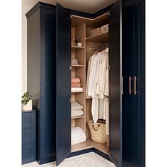 an open closet with clothes and towels in it