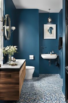 a bathroom with blue walls and flooring in the shower area, toilet and sink