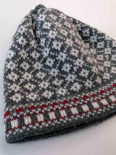 a gray and red hat sitting on top of a white table