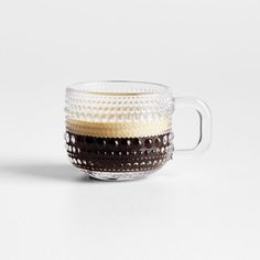 a glass cup with brown and white designs on the inside is sitting on a table