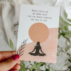 a person holding up a card with an image of a woman sitting in yoga position