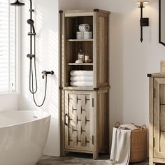 a white bath tub sitting next to a wooden cabinet with towels on top of it