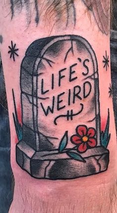 a man with a tattoo on his leg that says life's weird