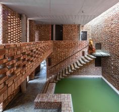 an indoor swimming pool with brick walls and steps leading up to the second floor area