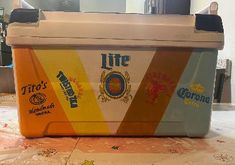 a cooler sitting on top of a table covered in paint