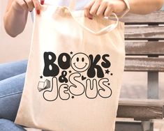 a woman sitting on a bench holding a bag with books and jesus printed on it