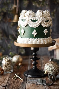 a green and white cake sitting on top of a wooden table next to other decorations