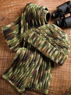 a knitted scarf and pair of binoculars on a wooden table