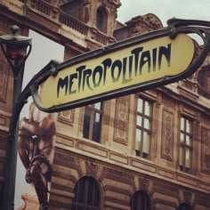 a street sign that reads metropolitan on it's pole in front of a building