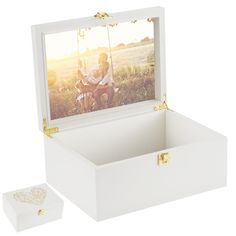 an open white box with a photo in the lid and two people on a swing