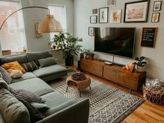 a living room filled with furniture and a large flat screen tv mounted on the wall