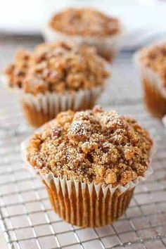 three muffins on a cooling rack with the words pumpkin pecan crunch muffins