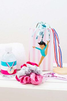 an assortment of personal items displayed on a white table with pink and blue accessories around it