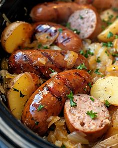 some sausages and potatoes are in a crock pot with parsley on top