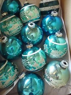 a box filled with blue and green christmas ornaments