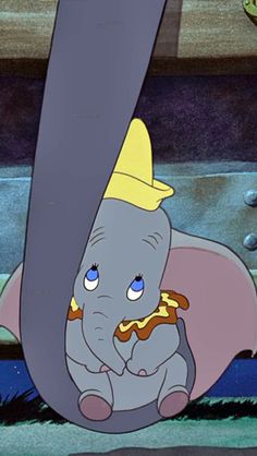 an elephant with a crown on it's head sitting in front of a giant letter