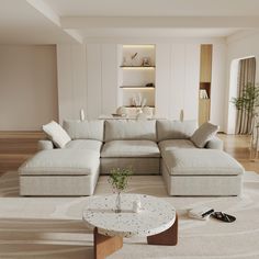 a living room with a large sectional couch and coffee table in it's center