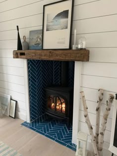 a fireplace with a wood burning stove in the middle and blue tiles on the wall