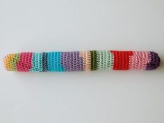 a multicolored crocheted object sitting on top of a white table next to a wall