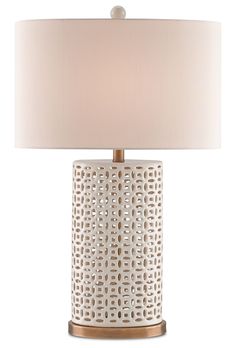 a white table lamp with a beige shade on the base and a gold metal frame