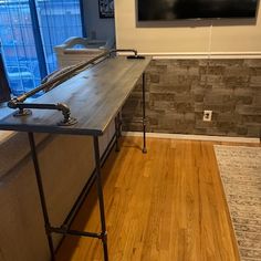 an industrial style kitchen island with stainless steel legs and wood flooring in front of a large window