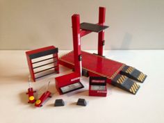 an assortment of toys including a toy fire truck, ladder and other items on a white surface