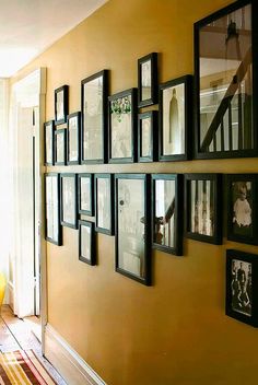 a wall with many framed pictures on it