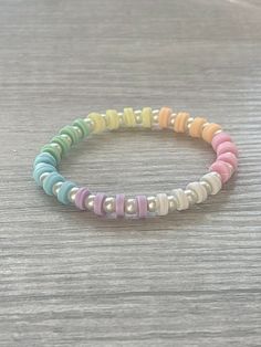 the multicolored beaded bracelet is on a wooden table