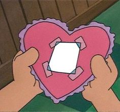 someone holding up a heart shaped paper cutout