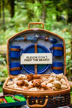 there is a basket full of stuffed animals on the table with a sign that says please don't feed the bears