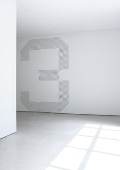 an empty room with white walls and a large number 5 painted on it's wall