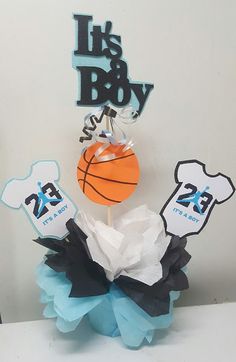 a cake topper with a basketball on it and two tags attached to it that say it's a boy